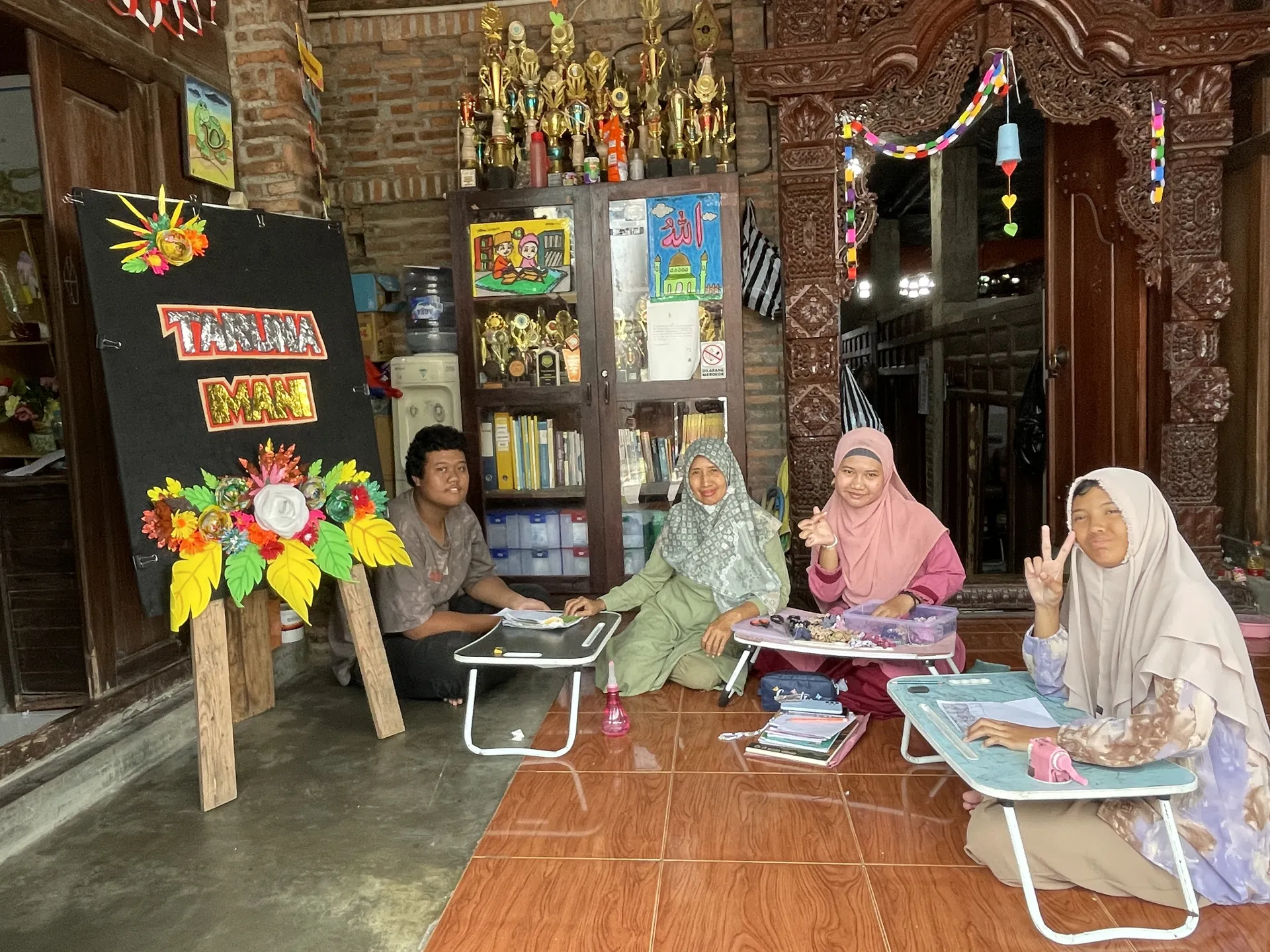 Siswa berhijab dan guru tersenyum bersama di kelas Sekolah Inklusi Taruna Imani YUKA Sleman